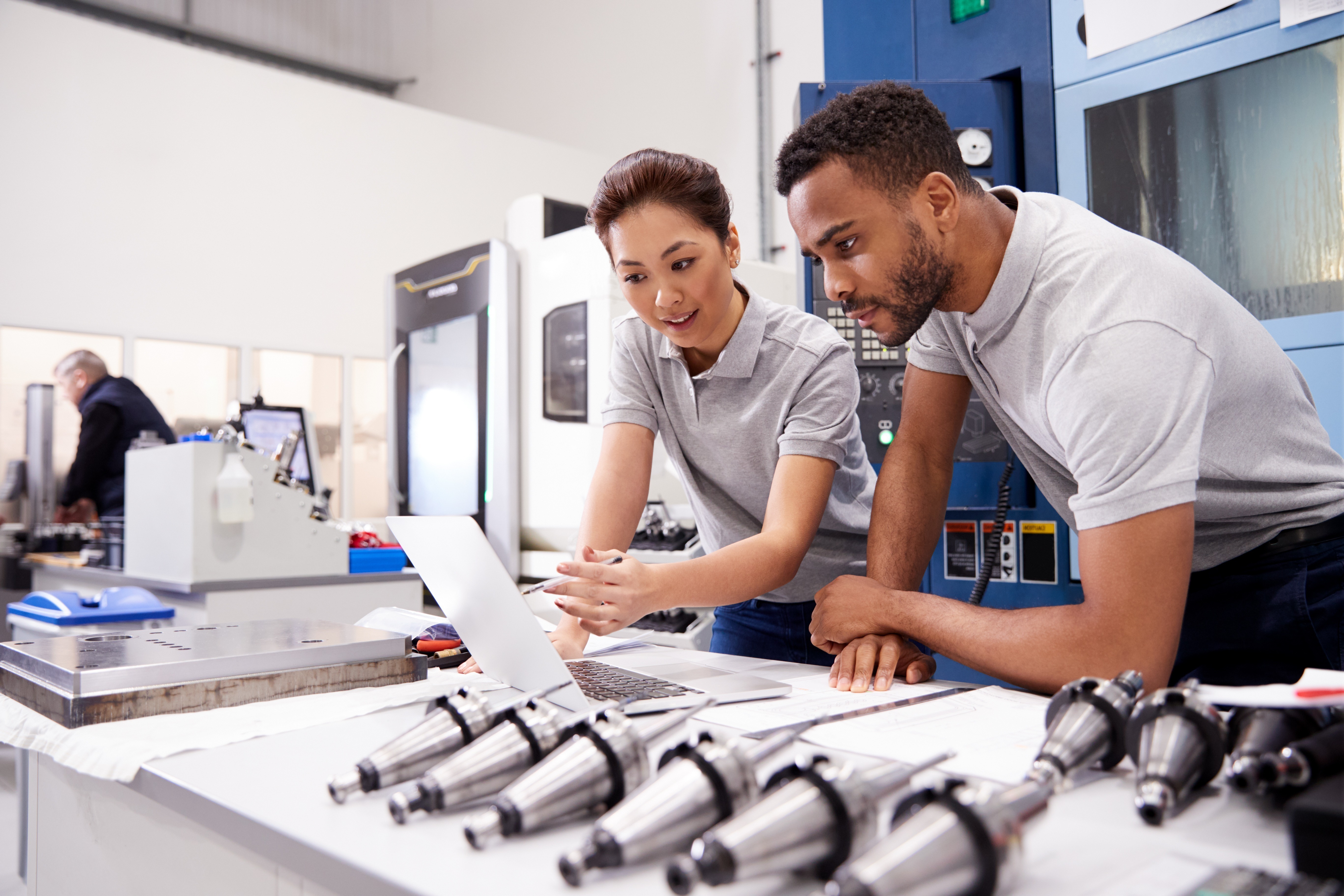 header-explore-dqs-ein mann und eine frau blicken zusammen auf computer in buero