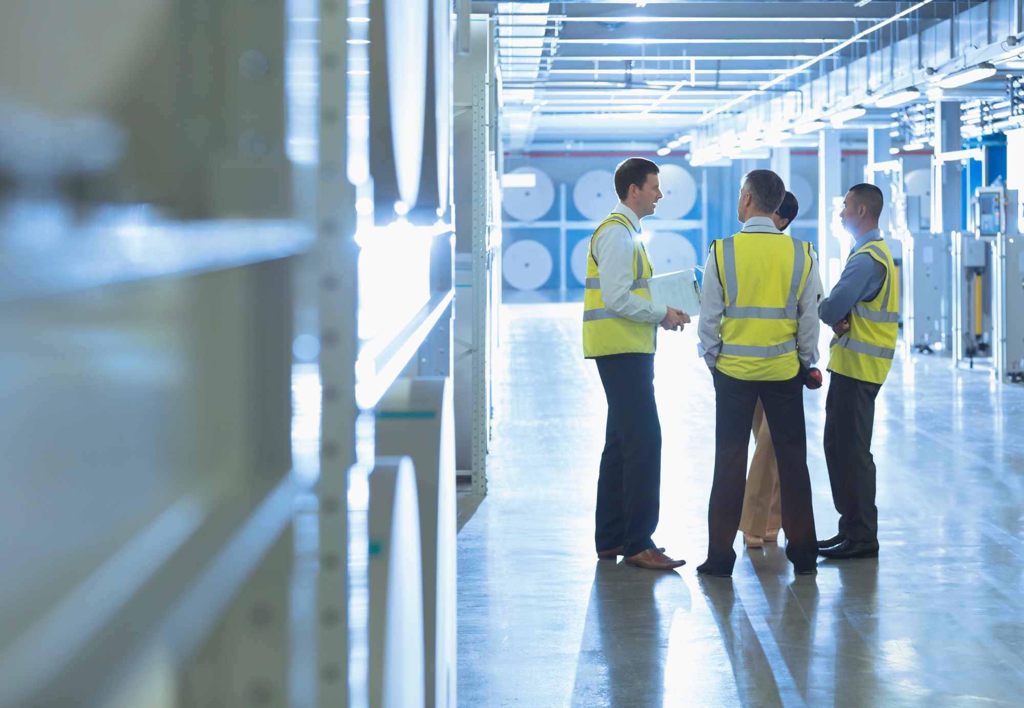 Workers talking in factory corridor 