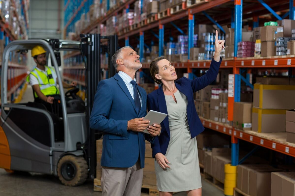 man and woman audit warehouse with shelves