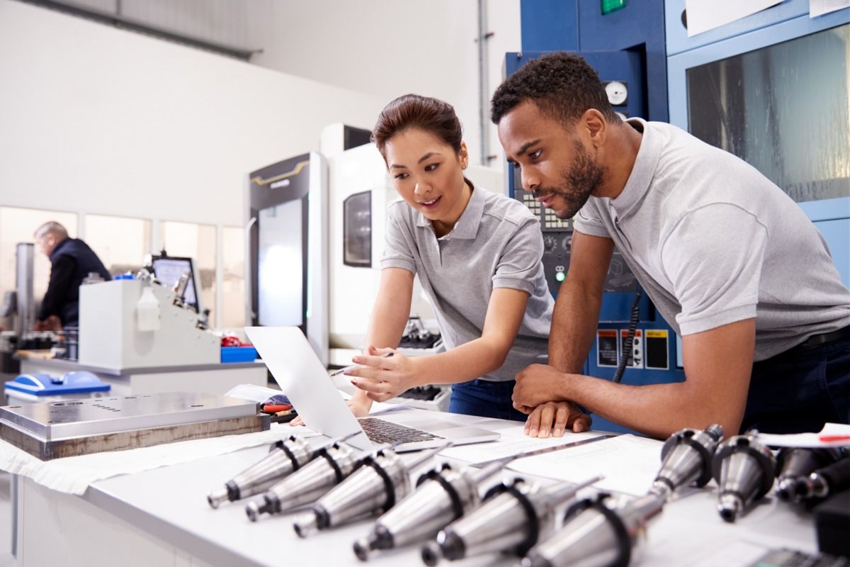 header-explore-dqs-ein mann und eine frau blicken zusammen auf computer in buero