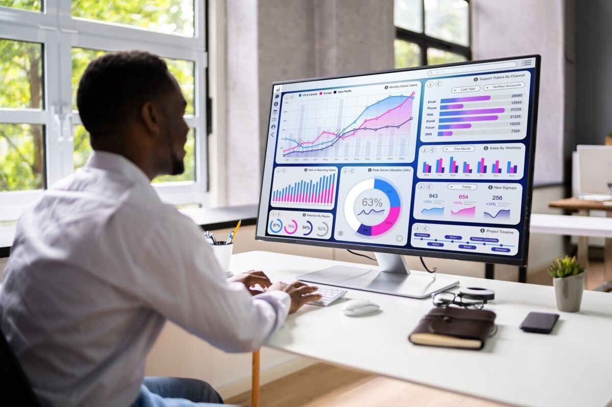 man at desk analyses data on his screen