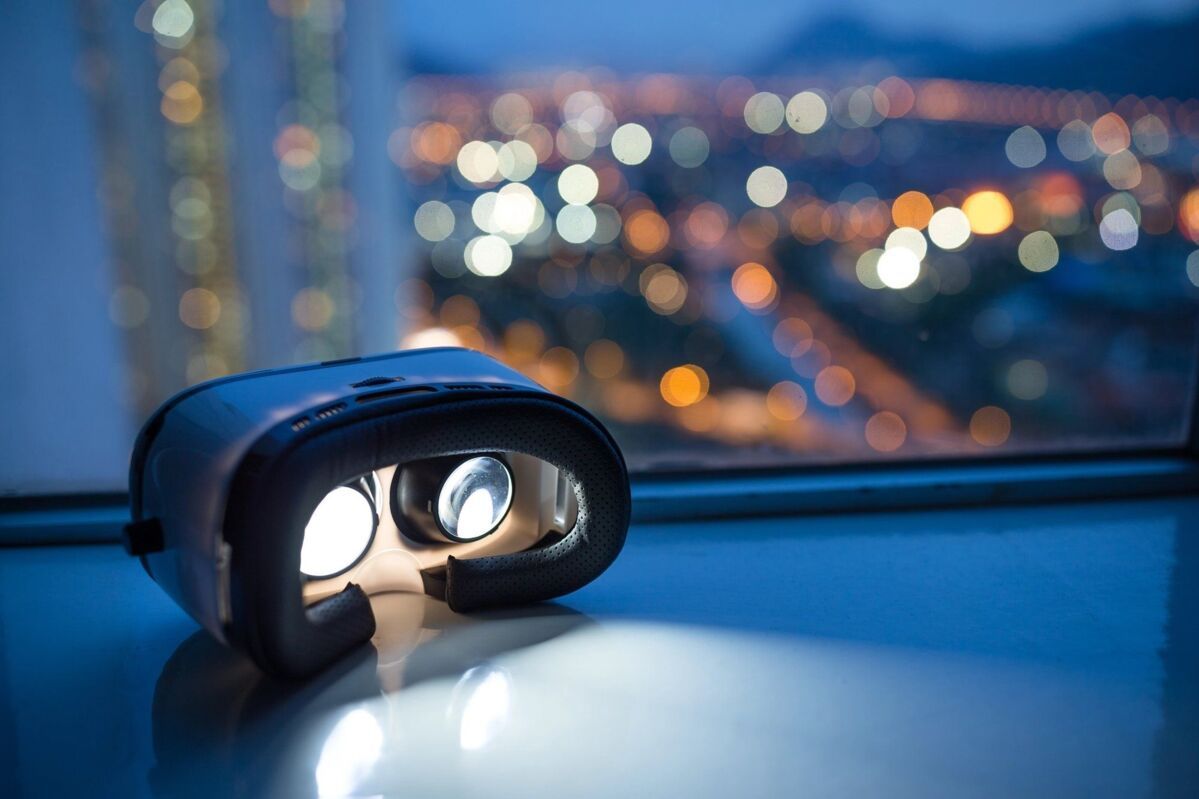 Virtual reality glasses on a windowsill in front of a skyline view