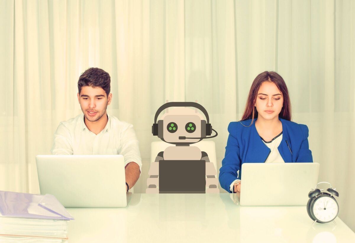 Man and woman with robot sitting at a table in the office to symbolize working with AI