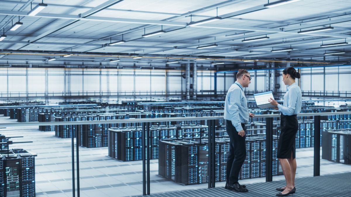 Man and a woman with a laptop in a server room